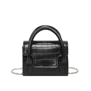 Petit sac carré noir à motif crocodile avec bandoulière chaîne sur fond blanc immaculé
