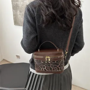 Secchiello alla moda con stampa leopardata e pelle marrone indossato da modella