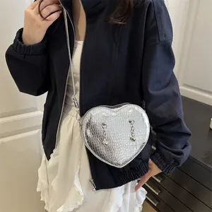 Silver heart-shaped crossbody bag with crocodile texture and metallic chain decoration