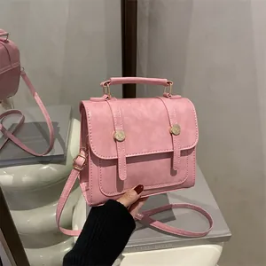 Petit sac à main rose en similicuir avec bandoulière et finitions métalliques dorées