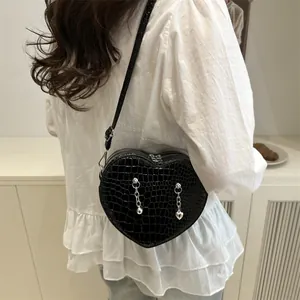 Chic black heart-shaped crossbody bag with crocodile texture and silver chain charms