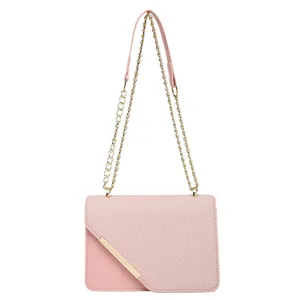 Elegant pink crossbody bag with gold metal trim and textured flap on white background