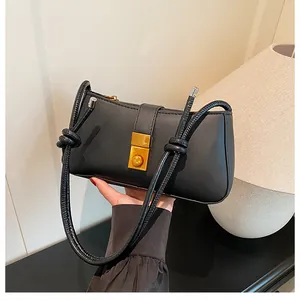 Close-up of black matte leather shoulder bag with a gold rectangular twist lock clasp