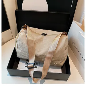 Détail de la sacoche en nylon beige froissé avec double fermeture éclair et logo métal FY