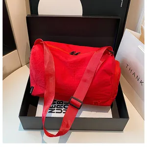Détail du sac cylindrique en nylon rouge avec logo FY gaufré dans son coffret cadeau