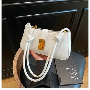 Detail of white faux leather shoulder bag featuring a knotted rope strap and gold lock