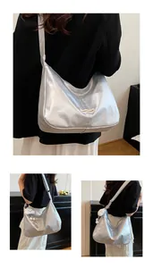 Detailopname van glanzende zilveren draagtas met wit geweven Fashion Bag-label