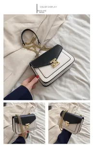 Detail view of the elegant black and white crossbody bag with gold chain strap and lock
