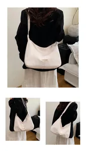 Detailweergave van een crème hobo-tas met modelabel en zachte PU-lederen textuur
