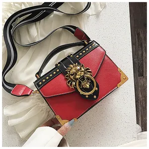 Red and black rivet handbag with golden lion head buckle and wide striped shoulder strap