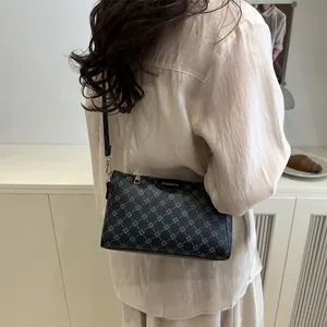 Dunkelgraue Umhängetasche mit geometrischem Muster und FASHION-Tag am Model