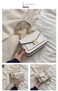 Detailed view of white crossbody bag with gold chain strap and metallic twist lock