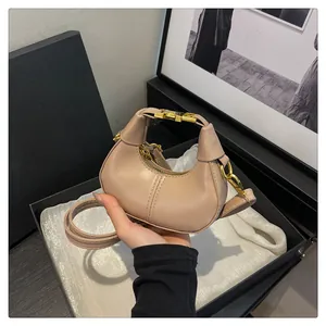 Détail du mini sac croissant beige avec poignée métallique dorée et bandoulière fine