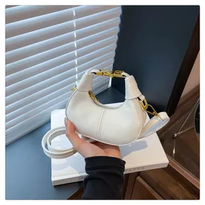 Détail du sac demi-lune en cuir blanc avec fermeture éclair dorée et coutures