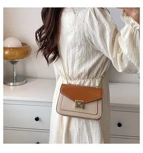 Detail of vintage crossbody bag with gold chain strap and two-tone leather texture