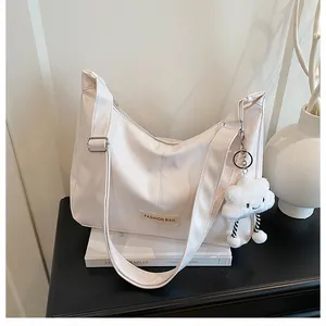 Detail van witte shopper met Fashion Bag-label en een lachende pluche wolkenhanger
