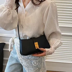 Elegant black leather baguette shoulder bag with a vintage gold buckle for women