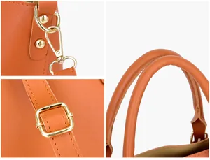 Détails de la texture du cuir litchi orange avec ferrures dorées et poignée solide