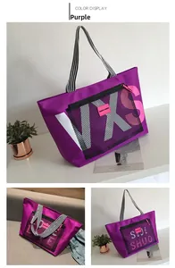 Detail view of purple nylon tote bag with black mesh pocket and striped handle straps