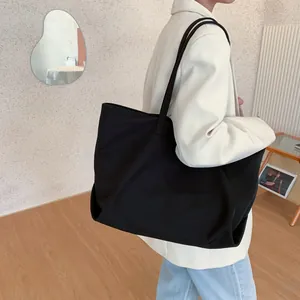 Grand sac cabas noir en nylon pour femme, spacieux avec un style minimaliste à l'épaule
