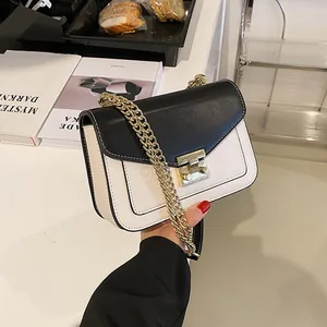 Contrast color black and white chain shoulder bag with gold hardware and flap design