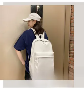 Detail of white PU backpack featuring front zipper pocket and minimalist school style