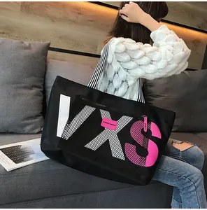 Detail of black waterproof tote with VXS letter print and striped shoulder strap