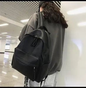 Detail view of the black leather texture and zipper design of the casual backpack