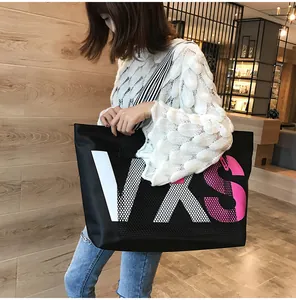 Detail of VXS letter print and mesh patchwork on a black large capacity tote bag
