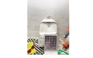 White PU leather backpack shown next to a tablet for internal storage size comparison