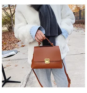 Detail einer braunen Vintage-Lederhandtasche mit goldenem Metallverschluss für den Alltag