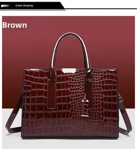 Detail of deep brown crocodile pattern handbag with glossy finish and silver metal hardware