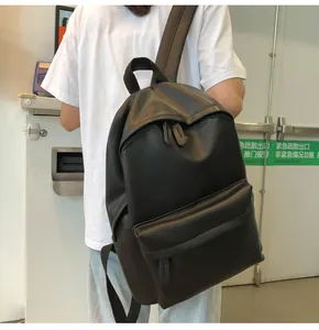 Close-up of minimalist black PU leather backpack showing soft texture and zip pockets