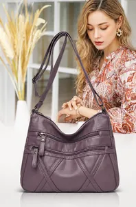 Detail of purple soft PU leather crossbody bag with multiple zippers and diamond quilting