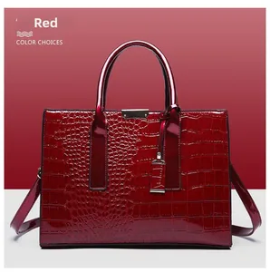 Detail view of wine red crocodile texture handbag with glossy finish and silver hardware