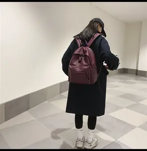 Rear view of a model wearing the burgundy PU leather backpack for school and daily casual use