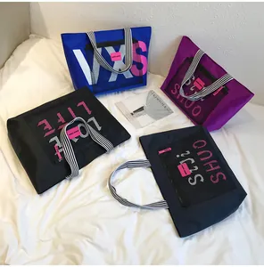 Detail of four colorful waterproof tote bags with striped handles and mesh front pockets