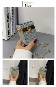 Close-up of sparkling blue rhinestone evening clutch bag with gold chain and clasp