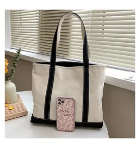 Detailed view of large canvas tote bag with black strap contrast in cozy indoor setting