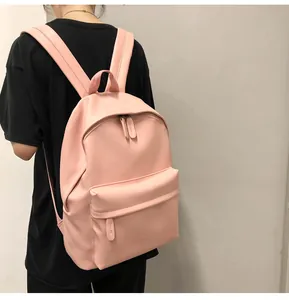 On-body view of a minimalist pink PU leather backpack with wide straps and spacious front pocket