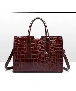 Detailed front view of burgundy crocodile pattern handbag with glossy patent finish