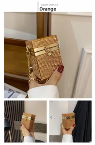 Detail of orange rhinestone mini evening bag with gold chain strap and crystal texture