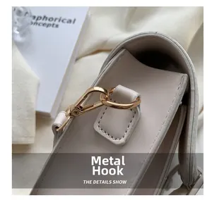 Detailopname van premium gouden metalen haken en stiksel op een beige leren tas