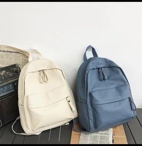 Detail of PU leather backpacks in cream and grey blue showing pebble grain texture