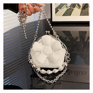 Detail view of a white flower petal chain bag with pearls and silver metallic beads