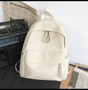 Detailed view of beige faux leather backpack with litchi texture on vintage desk