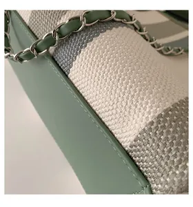 Dettaglio della trama in tweed e tracolla a catena della borsa a righe verdi a contrasto