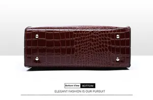 Detail view of reddish brown faux leather handbag base with crocodile pattern and gold studs