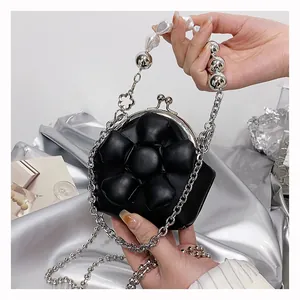 Detailed view of mini kiss-lock bag featuring 3D flower and pearl chain strap