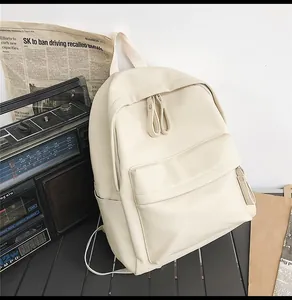 Detail of cream PU leather backpack with pebble texture and multiple zippered pockets